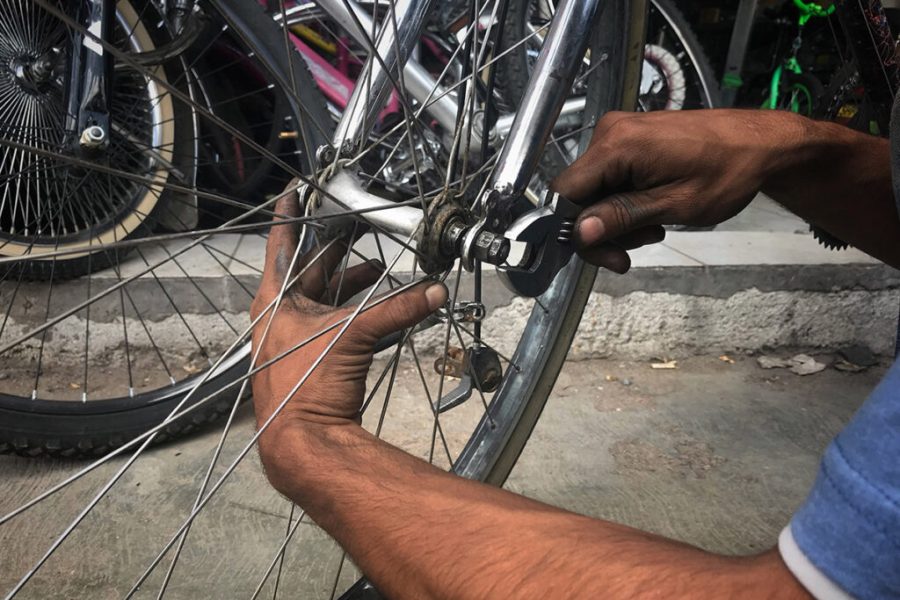 Jongman spring in om kinderhuiskinders se fietse te herstel